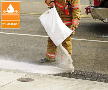 Räddningstjänst - brandman - som häller ut en säck med absorberande granulat på ett utsläpp på vägen. 