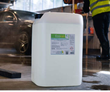 En 25-liters plastdunk med Ecoren avfettning i förgrunden, i bakgrunden tvättas en bil.