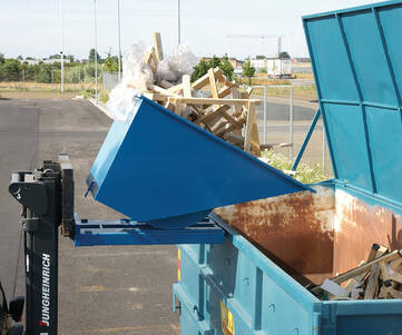 Tippcontainer som sitter på truckgafflar och tippar skräp ner i en sopcontainer.