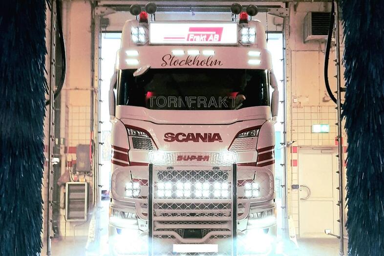 En vit Scania lastbil som åker in i en lastbilstvätt. 